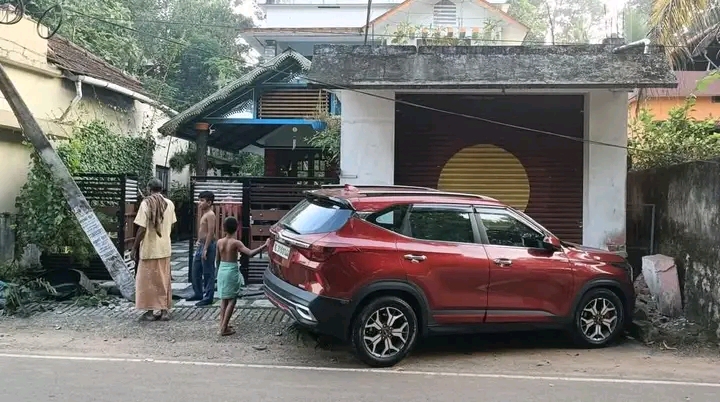 കാർ നിയന്ത്രണം വിട്ടു പോസ്റ്റിൽ ഇടിച്ച ശേഷം  മതിൽ ഇടിച്ചു തകർത്ത നിലയിൽ